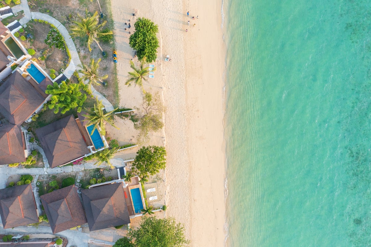 Aerial view top of a stunning beach resort on the island in Thailand, with pristine white sand and crystal-clear water