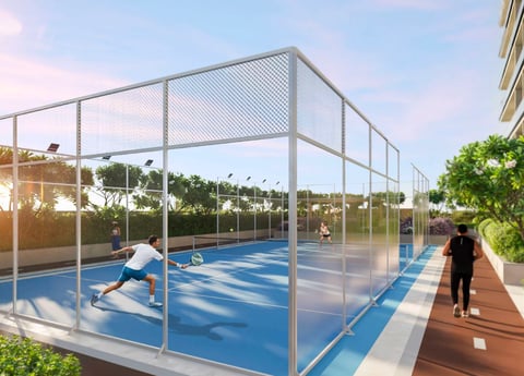 Modern rooftop paddle tennis court with blue playing surface, metal mesh fencing, and athletes in action during daytime