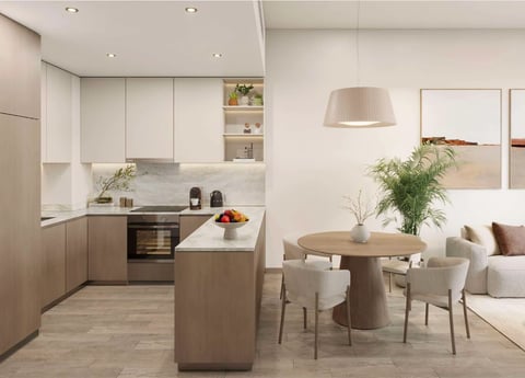 Modern open-plan kitchen and dining area with white cabinetry, wood accents, island counter, round dining table, and contemporary furniture
