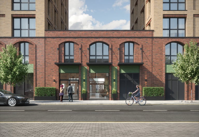 Modern storefront with arched windows in red brick building, street level entrance with people and cyclist, urban architecture