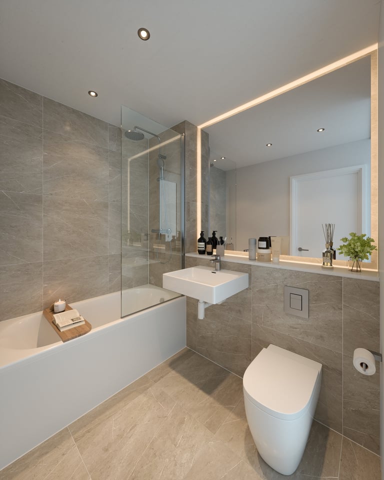 Modern bathroom with white bathtub, vessel sink, illuminated mirror, toilet, and gray tile walls