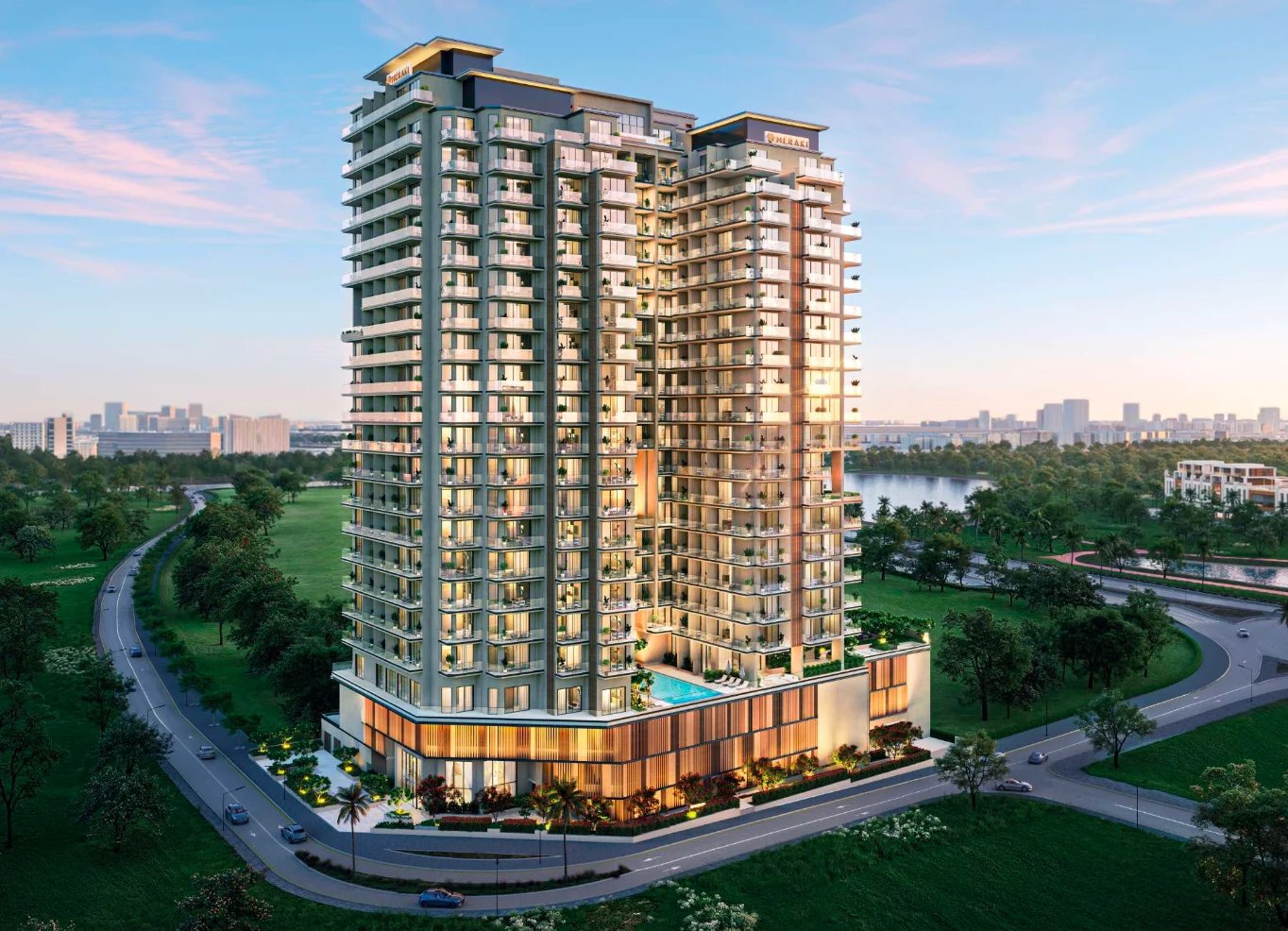 Modern high-rise residential building with illuminated facade at dusk, surrounded by green landscape and water view in urban setting.